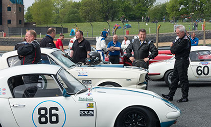Pre-1966 GT cars and drivers wait in the GP paddock before qualifying